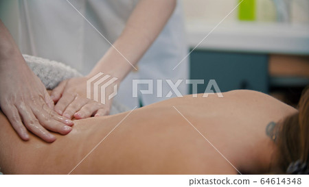 Massage treatment - massage master massaging womans back Massage treatment - massage master massaging womans back 64614348