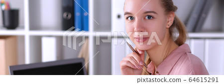 Young office employee sits at desk in front laptop Young office employee sits at desk in front laptop 64615291