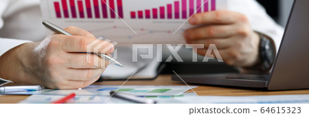 Businessman reviews statistical financial report Businessman reviews statistical financial report 64615323