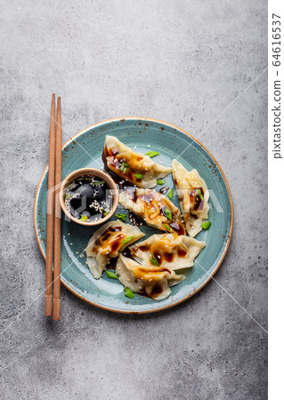 Asian dumplings on blue plate Asian dumplings on blue plate 64616537