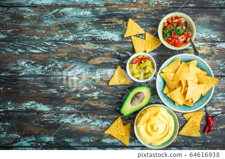 Tortilla chips and assorted dips 64616938