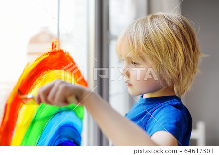 Little boy drawing on window rainbow while coronavirus quarantin Little boy drawing on window rainbow while coronavirus quarantin 64617301
