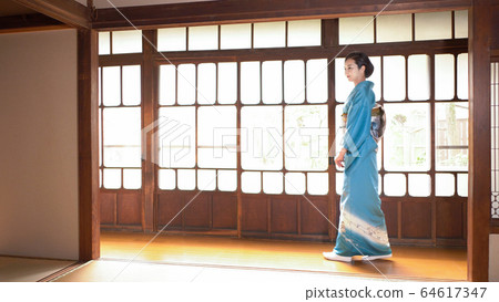 一個穿著和服的女人走在一座舊私人住宅的走廊上 64617347