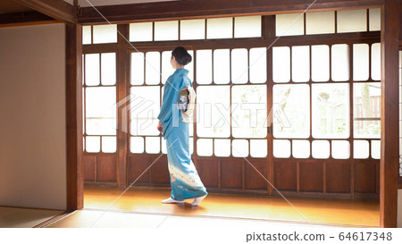 一個穿著和服的女人走在一座舊私人住宅的走廊上 64617348