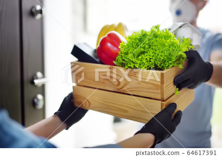 Courier or volunteer delivering shopping to woman Courier or volunteer delivering shopping to woman 64617391