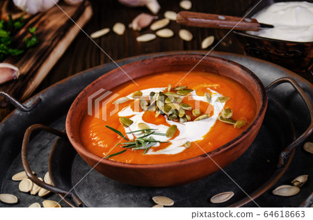 Clay dish with homemade rustic pumpkin soup with Clay dish with homemade rustic pumpkin soup with 64618663