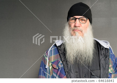 Mature bearded hipster man with eyeglasses thinking outdoors Mature bearded hipster man with eyeglasses thinking outdoors 64618841