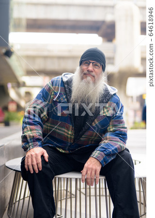 Mature handsome bearded man thinking in the city streets 64618946