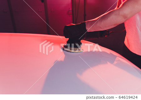 Car detailing - Man with orbital polisher in repair shop polishing car. Selective focus. Car detailing - Man with orbital polisher in repair shop polishing car. Selective focus. 64619424