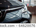 Closeup of a car headlight. Headlight of an expensive new car at a car dealership. 64620076