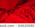 Close-up of folds of red fabric. Rolled up rag 64620080