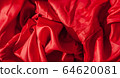 Close-up of folds of red fabric. Rolled up rag. 64620081