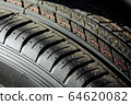 Tread of a new car tire at a car dealership. Close-up 64620082