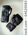 Black boxing gloves lie on a white table. 64620083