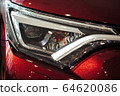Closeup of a car headlight. Headlight of an expensive new car at a car dealership. 64620086