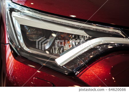 Closeup of a car headlight. Headlight of an expensive new car at a car dealership. Closeup of a car headlight. Headlight of an expensive new car at a car dealership. 64620086