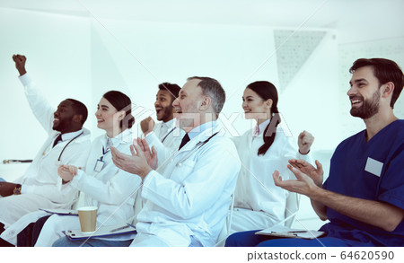 Cheerful doctors applauding during conference in clinic Cheerful doctors applauding during conference in clinic 64620590