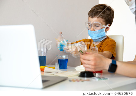 Serious young scientist doing interesting experiment at home Serious young scientist doing interesting experiment at home 64620676