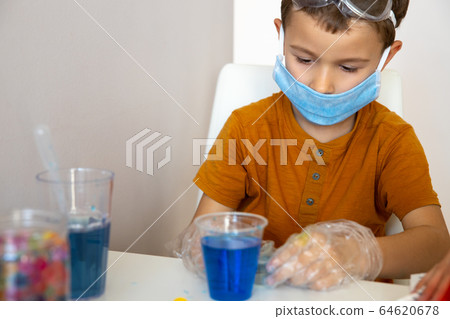 Serious brunette boy doing chemical experiment during game Serious brunette boy doing chemical experiment during game 64620678