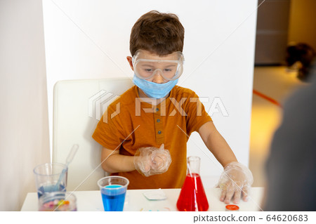 Kind little boy playing at home with water 64620683