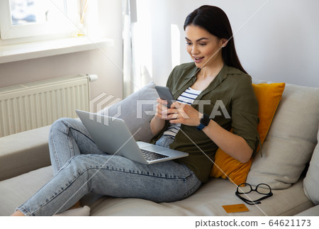 Amazed pretty lady using smartphone at home 64621173