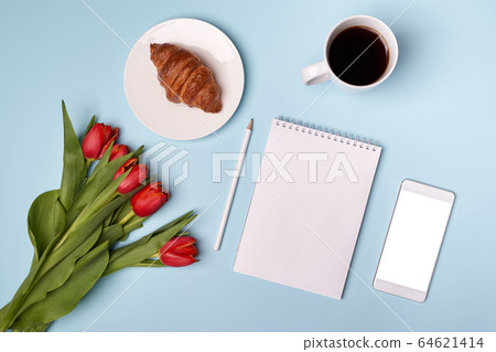 Cup of coffee, croissant, notepad, pen, phone and flowers 64621414