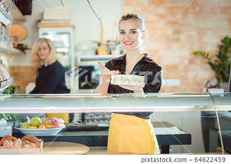 Women selling cheese at counter in a supermarket Women selling cheese at counter in a supermarket 64622459