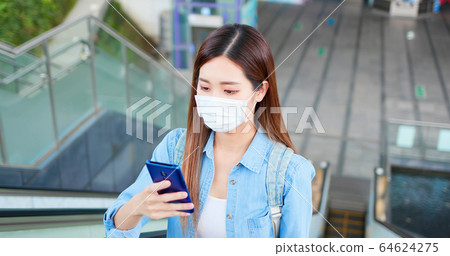 woman use phone with mask 64624275