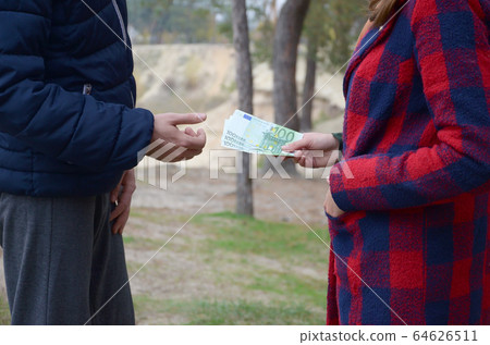 Girl transfers euro bills to the hands of a young Girl transfers euro bills to the hands of a young 64626511