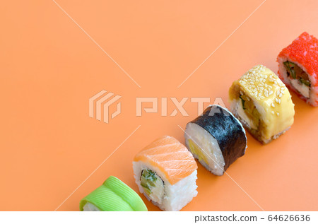 Different types of asian sushi rolls on orange 64626636