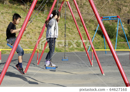 Brother and sister playing on a swing (10 and 5 years old) Brother and sister playing on a swing (10 and 5 years old) 64627168