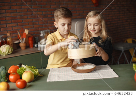 Children playing with a flour in a kitchen Children playing with a flour in a kitchen 64632423