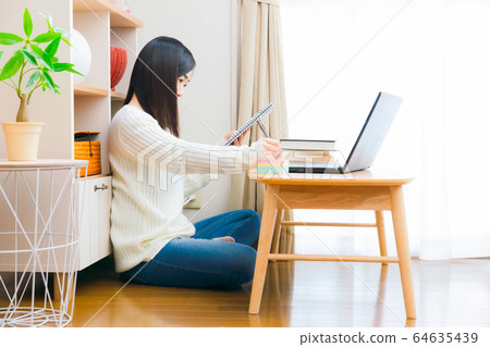 Woman writing on sticky notes, home notebook, reference book, PC 64635439
