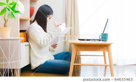 Woman checking documents at home Copy space 16: 9 Woman checking documents at home Copy space 16: 9 64635463