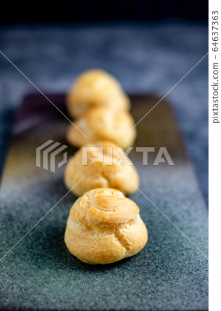 Eclair, choux filled vanilla custard cream and dusted with icing, dessert on a plate with copy space 64637363