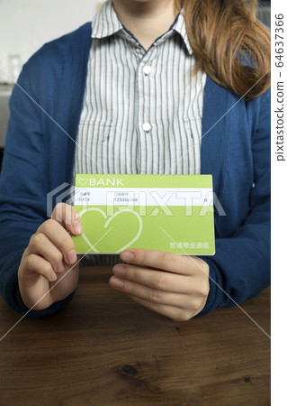 Woman hand holding a passbook Woman hand holding a passbook 64637366