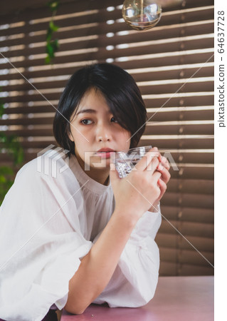 A woman drinking water 64637728