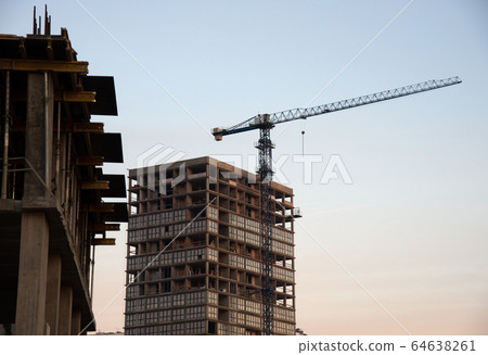 Tower cranes constructing a new residential building at a construction site Tower cranes constructing a new residential building at a construction site 64638261