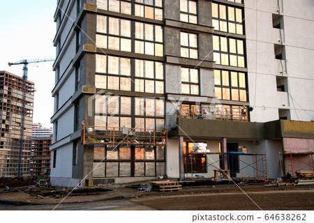 Suspended construction cradle on the background facade of the building Suspended construction cradle on the background facade of the building 64638262
