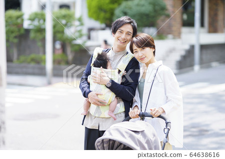 Parents taking a walk with their 3 month old baby Parents taking a walk with their 3 month old baby 64638616