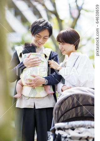 Parents taking a walk with their 3 month old baby Parents taking a walk with their 3 month old baby 64638659