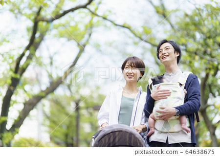 Parents taking a walk with their 3 month old baby Parents taking a walk with their 3 month old baby 64638675