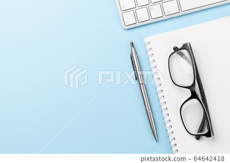Blue workplace with computer, supplies and glasses 64642418