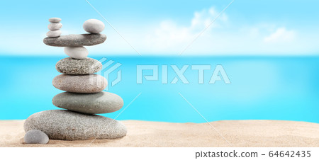 Pyramid of sea pebbles on a sunny sand beach Pyramid of sea pebbles on a sunny sand beach 64642435