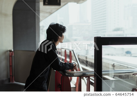 Man looking at the distance on skytrain. 64645754