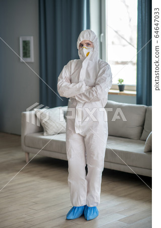 Woman in white workwear and protective eyeglasses looking ready to work 64647033