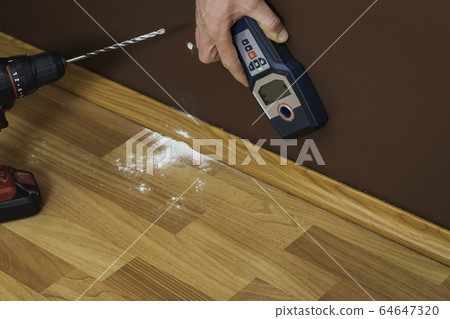 Man hand is scanning wall by cable detector to Man hand is scanning wall by cable detector to 64647320