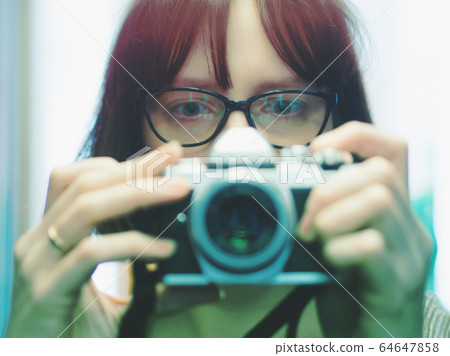 Young girl with glasses making selfie on camera 64647858