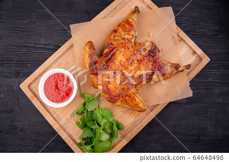 Chicken tobacco fried on coal with garlic, served with greens and ketchup Chicken tobacco fried on coal with garlic, served with greens and ketchup 64648498