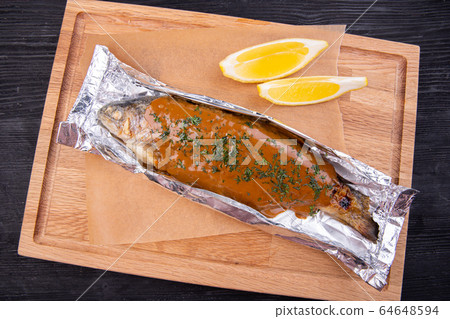 Trout baked in foil with sauce and herbs 64648594
